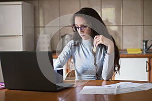 Young woman managing payments online with credit card