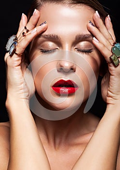 Young woman with with many bijouterie rings with stones on fin