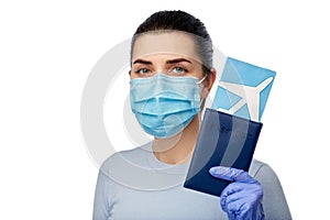 young woman in mask with air ticket and passport