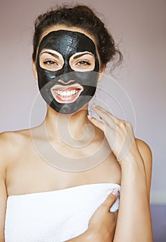 Young woman with a mask for the face of the therapeutic black mu