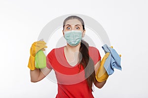 Young woman in mask and gloves holds spray bottle and rag isolated on a white background.