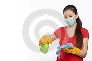 Young woman in mask and gloves holds spray bottle and rag isolated on a white background.