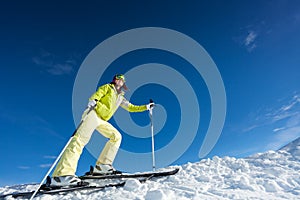 Young woman in mask holding ski poles and skiing