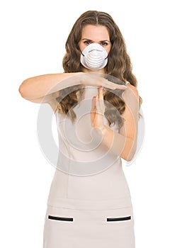 Young woman in mask showing stop gesture