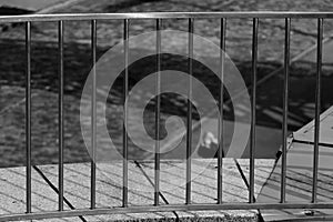 A young woman in a mask is standing under a pedestrian bridge.