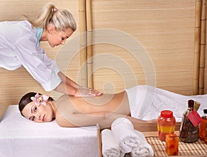 Young woman on massage table in beauty spa.