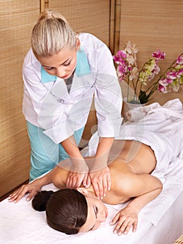 Young woman on massage table in beauty spa.