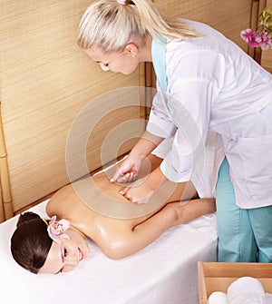 Young woman on massage table in beauty spa.