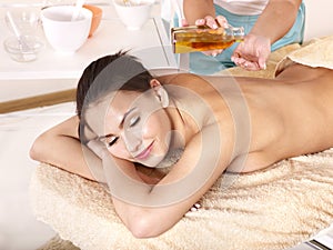 Young woman on massage table in beauty spa.