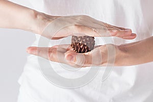 Young woman massage therapist in white shirt holds in hands spiky physio ball from sandal wood for relaxation ailment pain