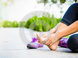 Young woman massaging her painful foot from exercising and running