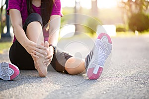 Young woman massaging her painful foot while exercising. Running Sport and excercise injury concept