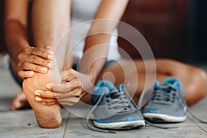 Young woman massaging her painful foot from exercising and running Sport and exercise concept.