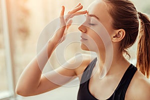 Young woman massaging third eye chakra