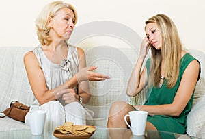 Young woman and mature mother having serious talking