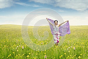 Young woman on the meadow with fabric