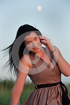 Young Woman In Meadow Talking on Mobile Phone