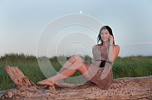 Young Woman In Meadow Talking on Mobile Phone