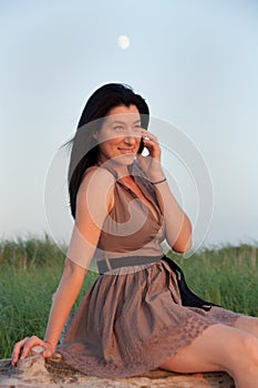 Young Woman In Meadow Talking on Mobile Phone