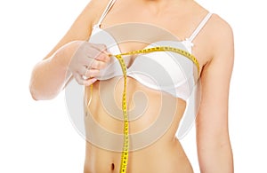 Young woman measuring her breast