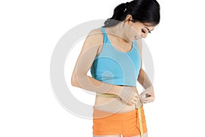 Young woman measuring her slim waistline
