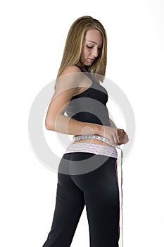 Young woman measuring her waist