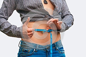 Young woman measuring her waist