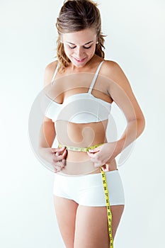 Young woman measuring her waist by measure tape. photo