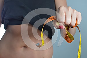 Young woman measuring waist