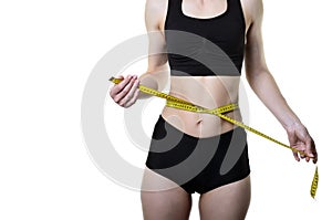 Young woman measuring waist with measuring tape, on whi