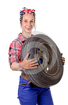Young woman mechanic with a car wheel