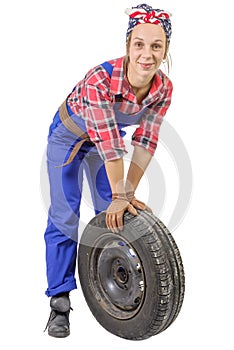 Young woman mechanic with a car wheel