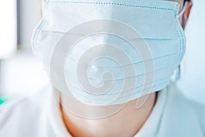 Young woman in medical face protection mask indoors on laboratory background