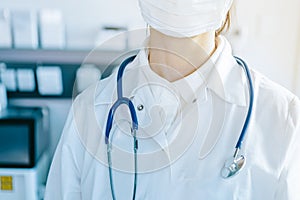 Young woman in medical face protection mask and stethoscope indoors on laboratory background