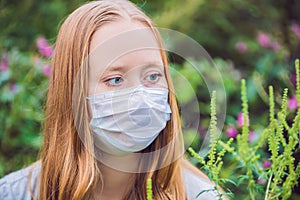 Young woman in a medical mask because of an allergy to ragweed