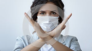 Young woman in medical mask show stop pandemic hand gesture