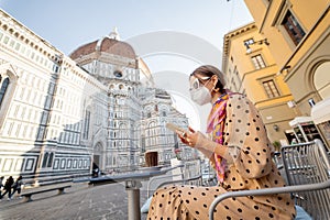 Woman in medical mask at cafe near Duomo cathedral in Florence