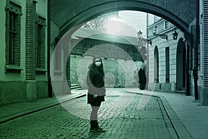Young woman in medical mask stands on empty Florianska street. coronavirus pandemic in world, self-isolation, distance between photo