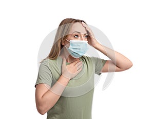 Young woman in medical mask suffering from pain during breathing on white background