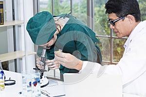 Young woman medical student and research assistant with microscopes