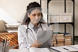 Young woman medical worker use pad study information on website