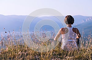 Young woman meditated on the top of mountain