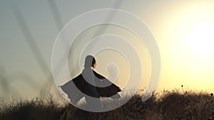 Young woman meditates, dances and whirls at sunrise, sunset on the seashore. Silhouette of a woman, meditation, relaxation, vacati