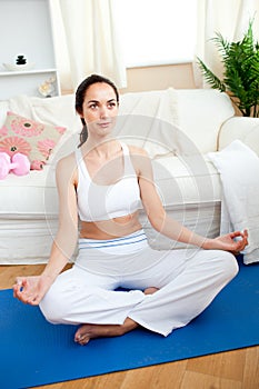 Young woman meditating in her living-room photo