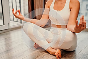 Young woman meditating at home. Girl practicing yoga in class. Relaxation at home, body care, balance, healthy lifestyle