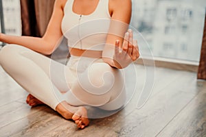 Young woman meditating at home. Girl practicing yoga in class. Relaxation at home, body care, balance, healthy lifestyle