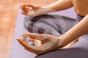 Young woman meditating in the lotus pose at home. Practicing yoga indoors. Harmony, yoga practice, balance, meditation