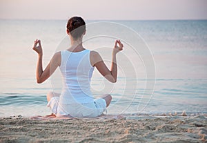 Young woman meditating near the sea