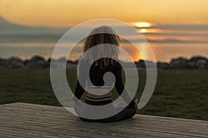 Young woman meditating by peaceful sea photo