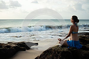 Young woman meditating, practicing yoga and pranayama with gyan mudra at the beach, Bali